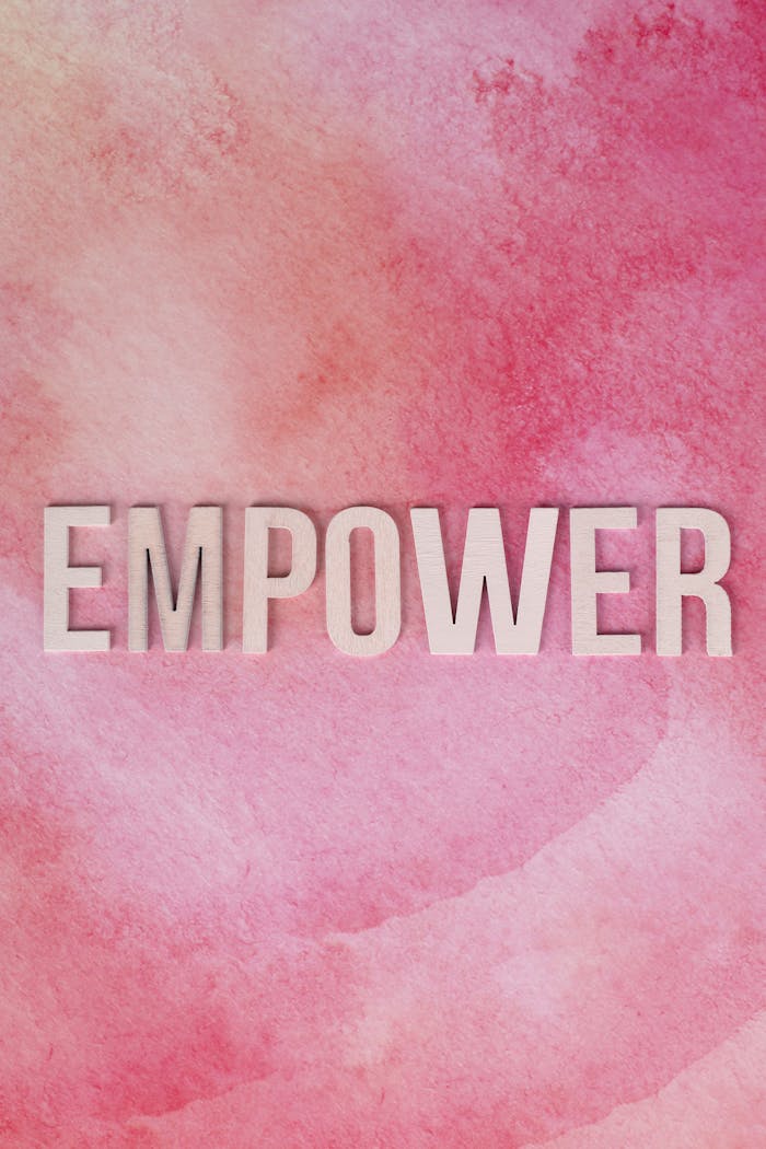 Inspiring message 'EMPOWER' on a pink watercolor texture, symbolizing strength and positivity.